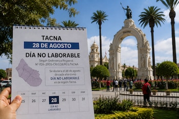 Una mano sostiene un anuncio de día no laborable frente al Arco Parabólico y la catedral en el Paseo Cívico de Tacna