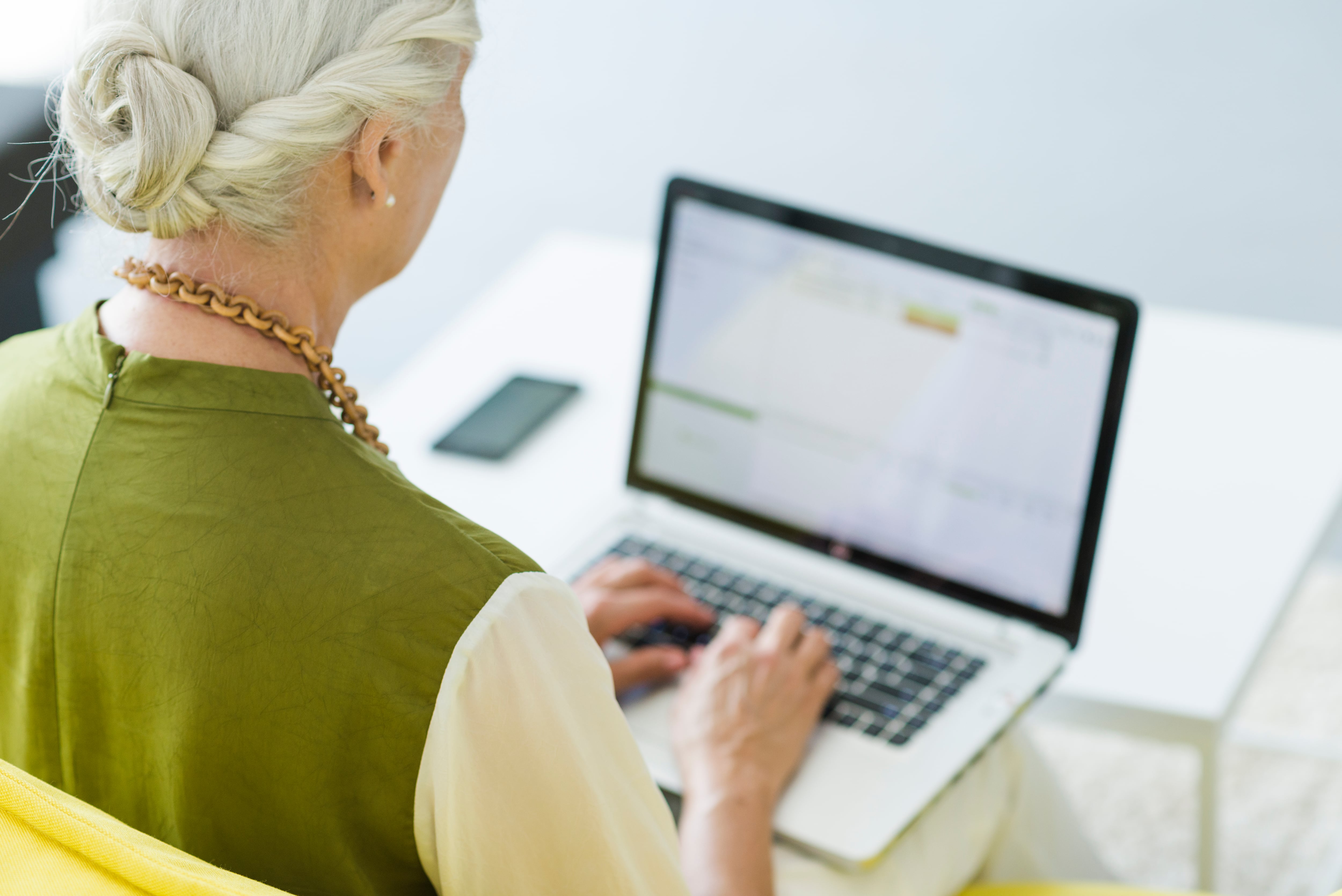 Una mujer en edad de jubilación trabajando con su ordenador (Freepik)