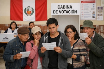 Cinco votantes de diversas edades examinan cédulas de sufragio en un centro electoral de Perú, frente a una cabina y una bandera peruana al fondo.