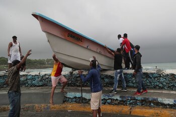IMAGEN DE ARCHIVO. Personas sacan un bote de la playa antes de la llegada de la tormenta tropical Fred en Santo Domingo, República Dominicana, Agosto 11, 2021. REUTERS/Ricardo Rojas