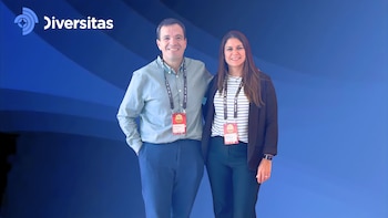 Hombre y mujer sonrientes con acreditaciones de evento LACNIC, uno con camisa celeste y otro con chaqueta negra. Fondo azul con logo Diversitas