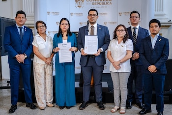 Seis personas, tres hombres y tres mujeres, posan formalmente frente a un logo del Congreso de la República. Dos de ellas sostienen documentos en sus manos