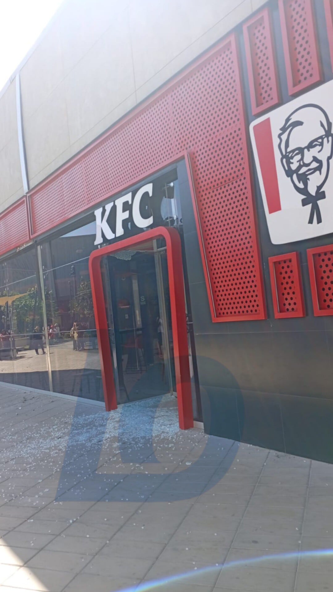 La fachada de la sede de KFC en Ica muestra una puerta de vidrio destrozada y cristales esparcidos en el suelo, resultado de los daños materiales tras el sismo que afectó la región. (Ica Rec Noticias)
