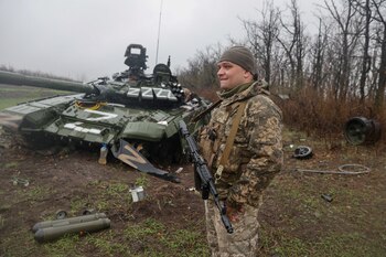 Un miembro del servicio ucraniano se encuentra junto a un tanque ruso dañado T-72 BV, mientras continúa el ataque de Rusia contra Ucrania, en la región de Donetsk, Ucrania, 13 de abril de 2022. (REUTERS/Serhii Nuzhnenko)
