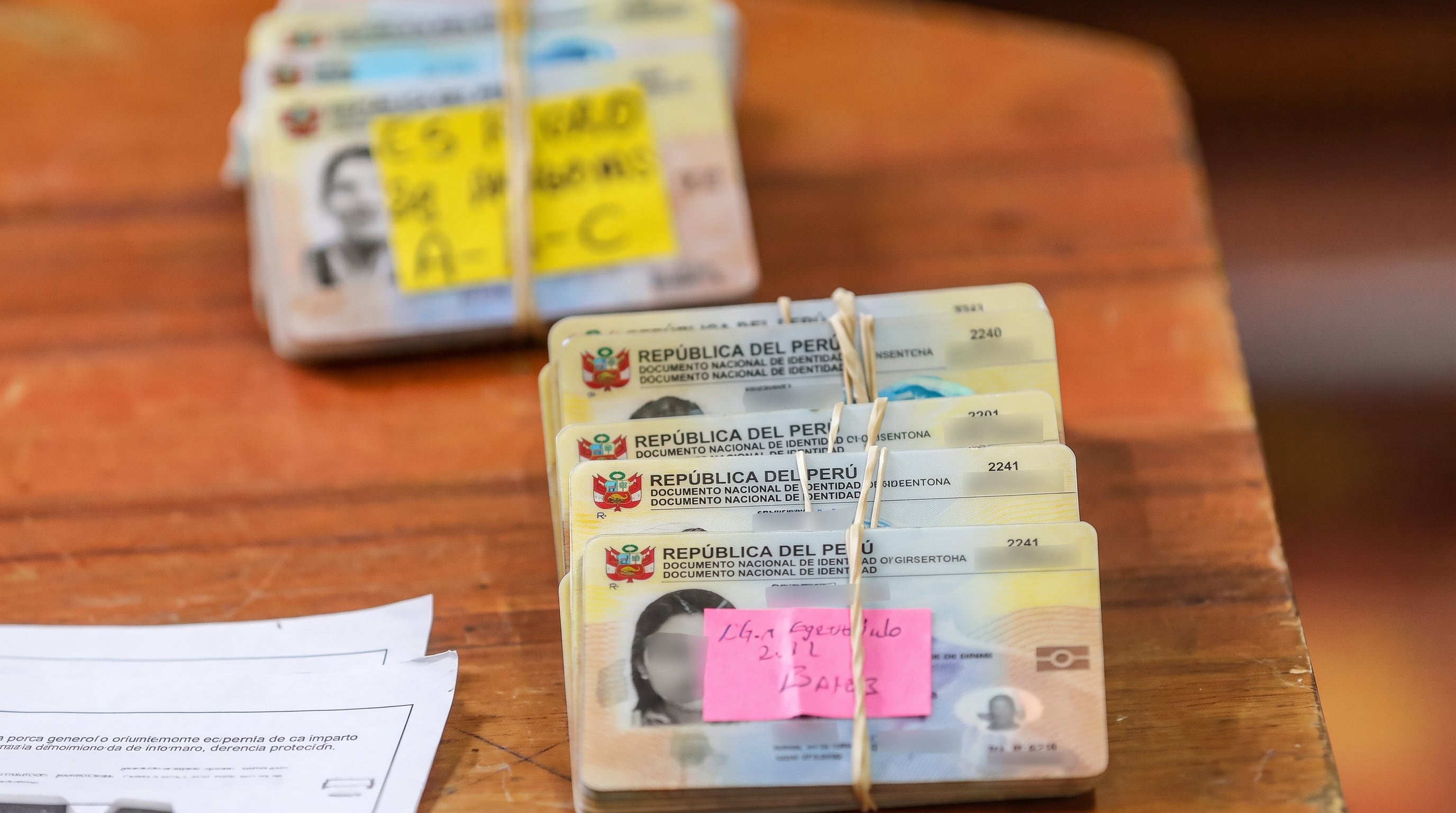 Múltiples Documentos Nacionales de Identidad (DNI) se encuentran apilados y listos para ser entregados durante las campañas gratuitas de documentación del Reniec en Perú. (Andina Noticias )