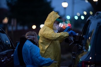 A healthcare worker administers a coronavirus nasal swab test at a drive-thru testing site at ProHEALTH Urgent Care of Jericho in New York, March 18, 2020. A vast majority of those infected with the coronavirus will develop only mild to moderate symptoms, but many people remain frightened and wonder how and when to seek medical care. (Johnny Milano/The New York Times)