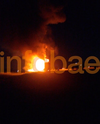 Gran incendio con llamas y humo naranja rojizo contra un fondo negro. El logo de Infobae en tono sepia está sobrepuesto en la imagen
