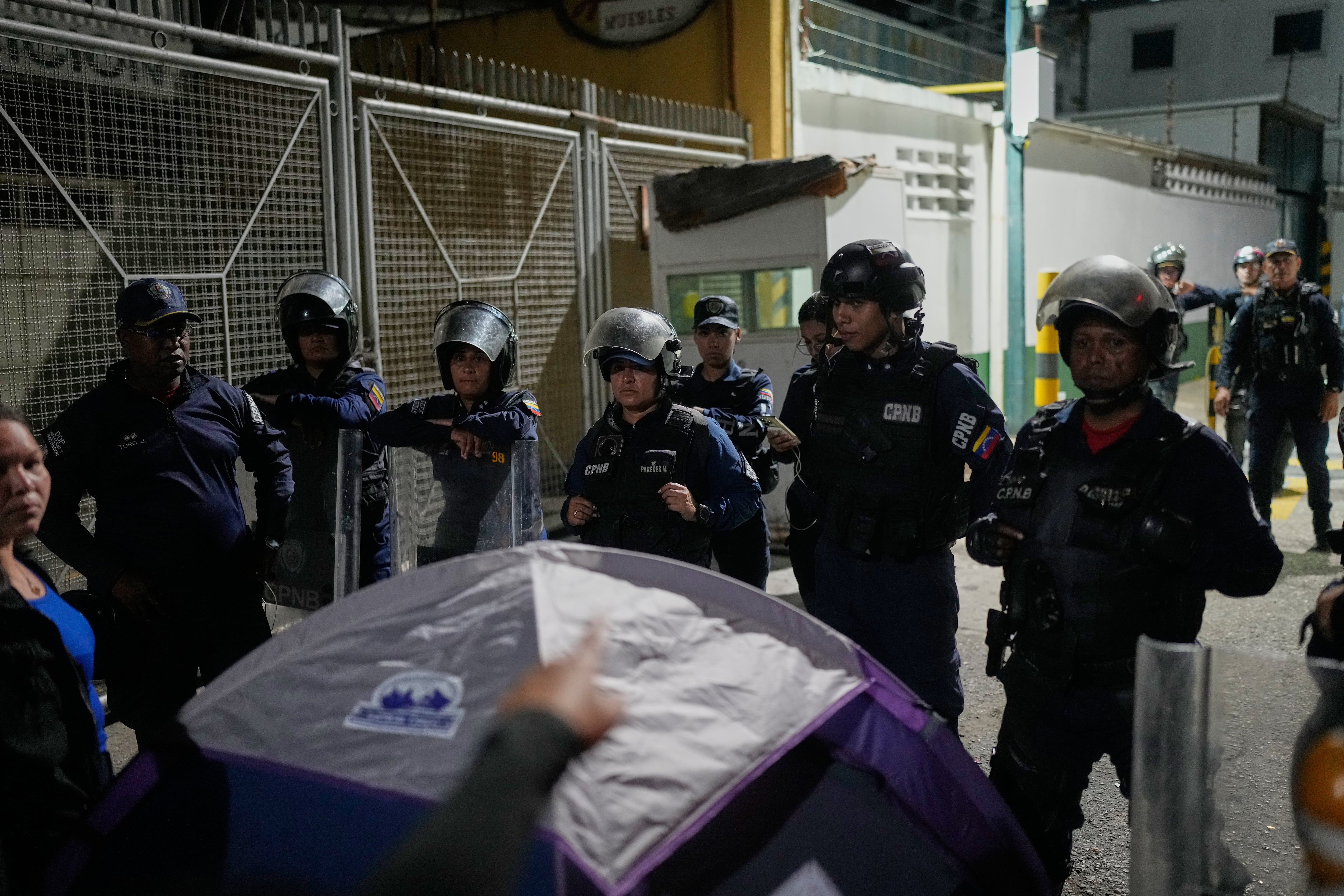 Un familiar de un preso político señala a la policía afuera del centro de detención Zona 7 de la Policía Nacional Bolivariana, el martes 20 de enero de 2026, en Caracas, Venezuela (AP Foto/Matías Delacroix)