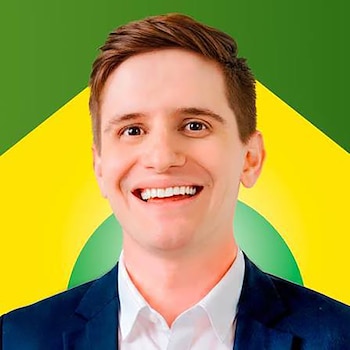 Retrato de un hombre joven con saco azul y camisa blanca, sonriendo sobre un fondo con diseño de color verde y amarillo