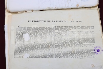 Antiguo documento de papel con texto impreso en español y título "EL PROTECTOR DE LA LIBERTAD DEL PERU". Incluye un sello circular morado