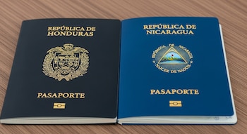 Dos pasaportes abiertos sobre una mesa de madera. Uno es oscuro de Honduras con su escudo, el otro es azul de Nicaragua con su escudo.
