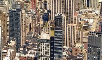 Vista aérea detalhada de arranha-céus e arranha-céus de uma cidade, com uma nova torre no meio.