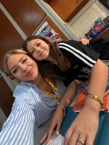 Evangelina Anderson, de camisa a rayas, y su hija Emma Demichelis posan sonrientes, con un cartel de cumpleaños y útiles escolares al fondo