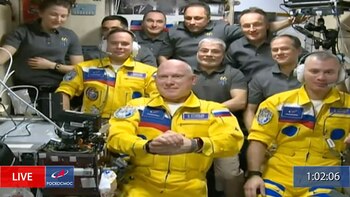 In this frame grab from video provided by Roscosmos, Russian cosmonauts Sergey Korsakov, Oleg Artemyev and Denis Matveyev are seen during a welcome ceremony after arriving at the International Space Station, Friday, March 18, 2022, the first new faces in space since the start of Russia’s war in Ukraine. The crew emerged from the Soyuz capsule wearing yellow flight suits with blue stripes, the colors of the Ukrainian flag. (Roscosmos via AP)