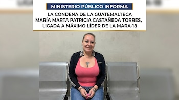Mujer con cabello rubio, blusa rosa y chaqueta oscura, sentada en banca metálica. Lleva esposas en sus muñecas y un tatuaje en el pecho.