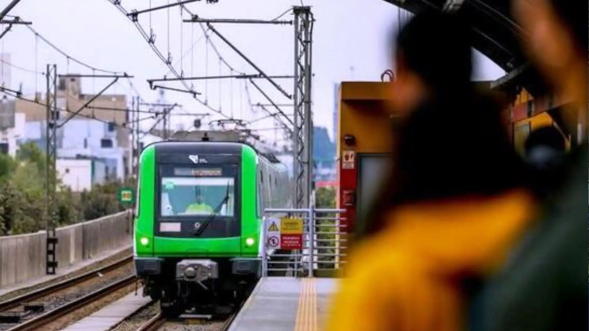 Un tren de la Línea 1 del Metro de Lima arriba a la plataforma de una estación, mientras una persona espera en primer plano. (Andina)