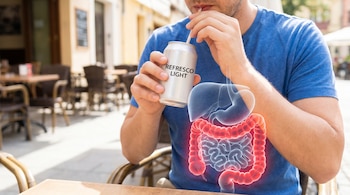 Hombre bebiendo un refresco light de una lata con pajita, mientras una representación digital de su colon se ilumina en rojo sobre su abdomen.