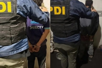 Dos hombres esposados de espaldas a la pared son custodiados por agentes policiales con chalecos identificados con la sigla PDI