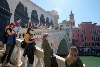 Una manifestación organizada por propietarios de pequeñas empresas pasa por el puente de Rialto para conmemorar a los trabajadores de la salud que murieron por el coronavirus, en Venecia, Italia, 4 de mayo de 2020. (REUTERS / Manuel Silvestri)