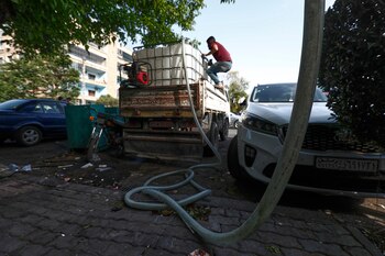Un trabajador suministra agua desde