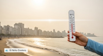 Mano sostiene termómetro con 30 grados Celsius en una playa con olas, arena, edificios urbanos y cielo claro; texto "El Niño Costero" en esquina.