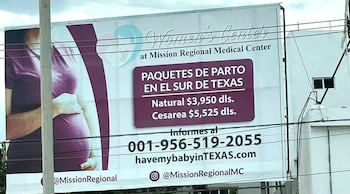 Un cartel publicitario muestra el abdomen de una mujer embarazada y texto que detalla paquetes de parto y precios de Mission Regional Medical Center