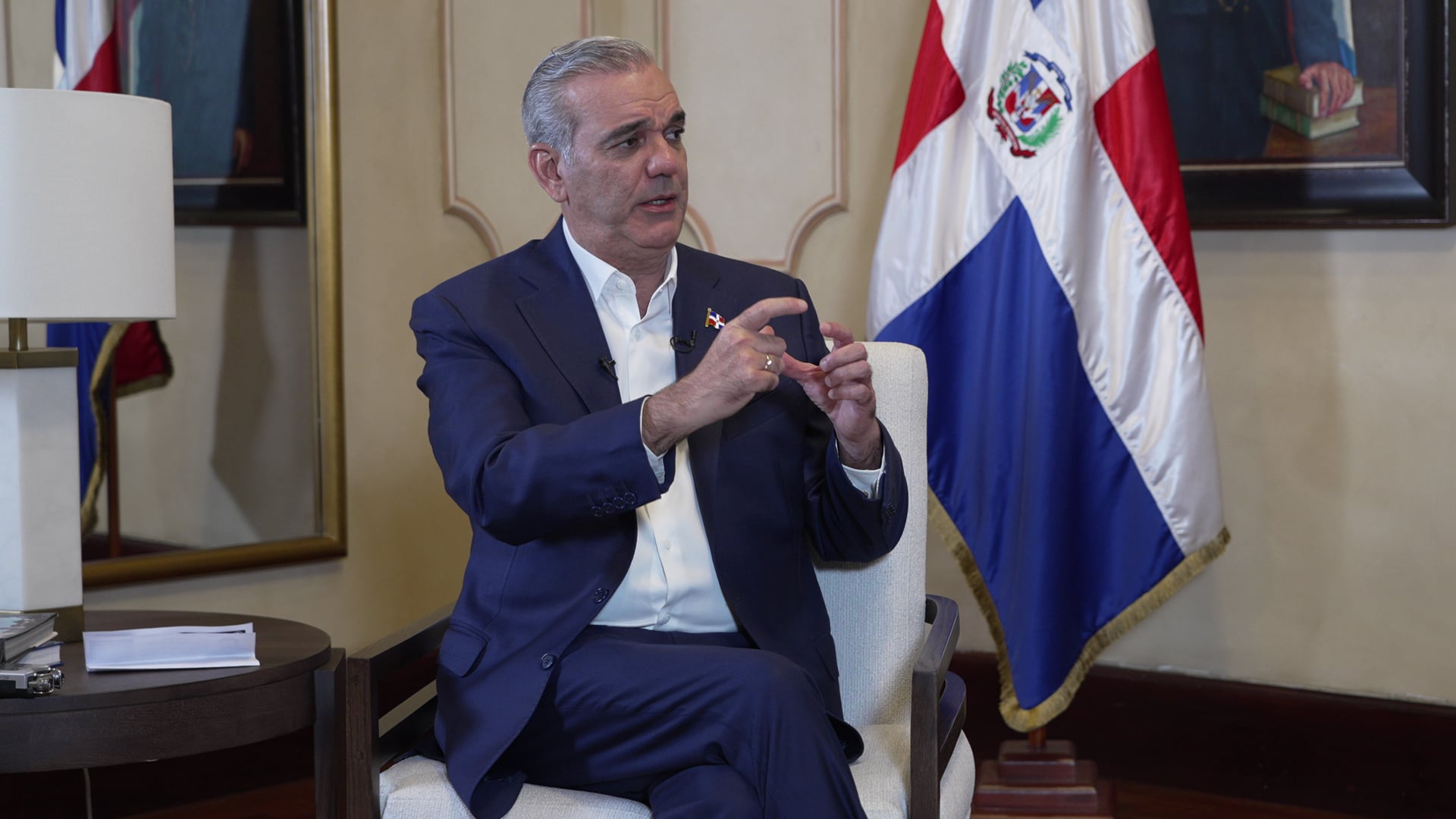 El presidente de la República Dominicana, Luis Abinader, durante una entrevista exclusiva donde abordó diversos temas de relevancia para el país, con la bandera dominicana de fondo.