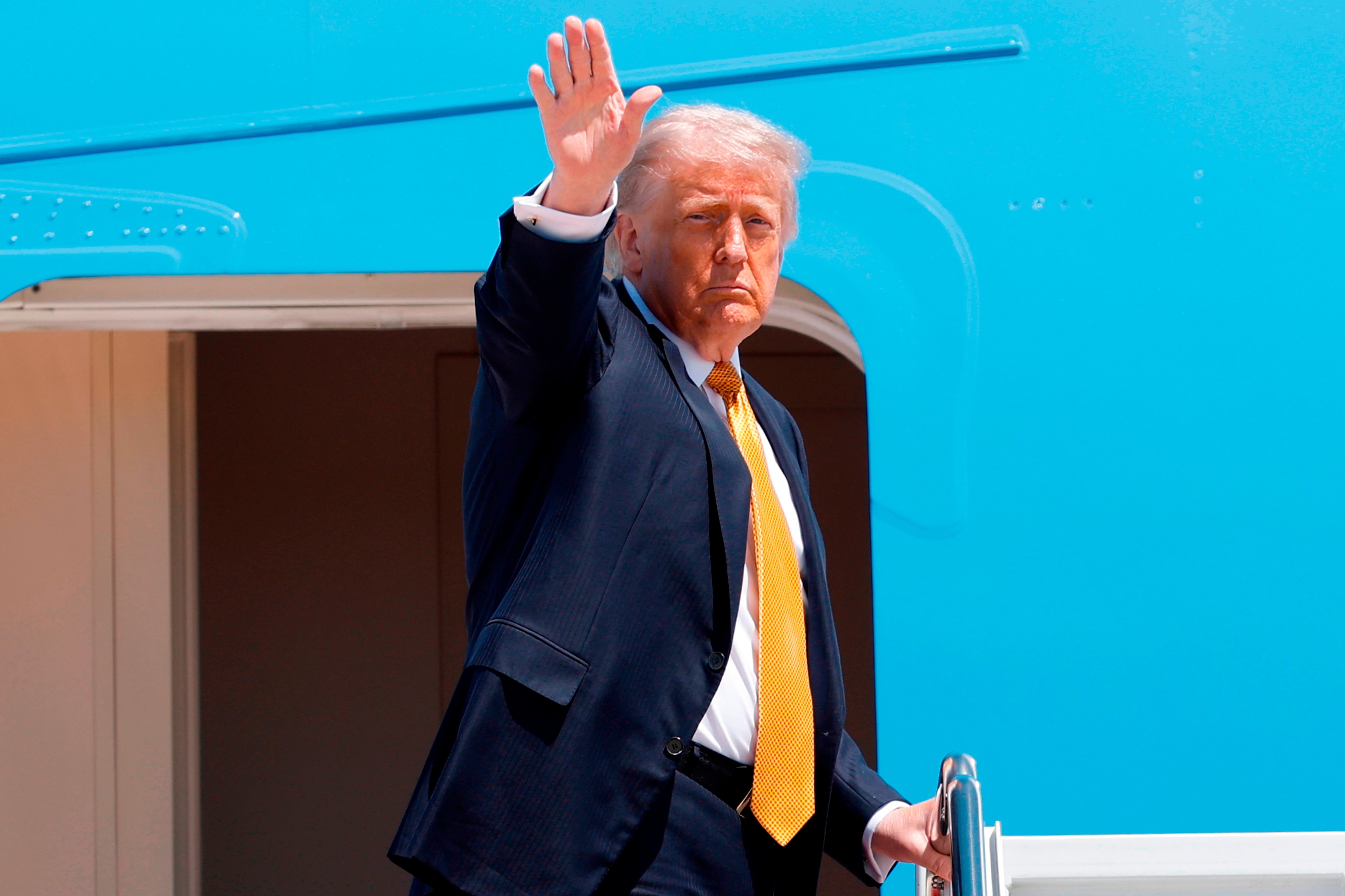 El presidente de EEUU, Donald Trump, saluda con la mano desde las escaleras del Air Force One mientras sube en la Base Conjunta Andrews, en Maryland, el martes 12 de mayo de 2026, para emprender un viaje a China con el fin de reunirse con el presidente chino Xi Jinping (AP/Luis M. Álvarez)
