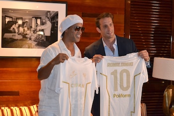 El astro brasileño Ronaldinho Gaúcho y el presidente del Ravenna, Ignazio Cipriani, posan con camisetas durante el anuncio, el 15 de junio en Miami, de su regreso al fútbol profesional a los 46 años de la mano del Ravenna FC italiano (EFE/ Antoni Belchi)
