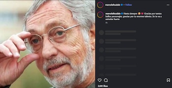 Primer plano de Luis Brandoni, hombre mayor con pelo y barba grises, ajustándose gafas redondas con montura dorada, con mirada atenta