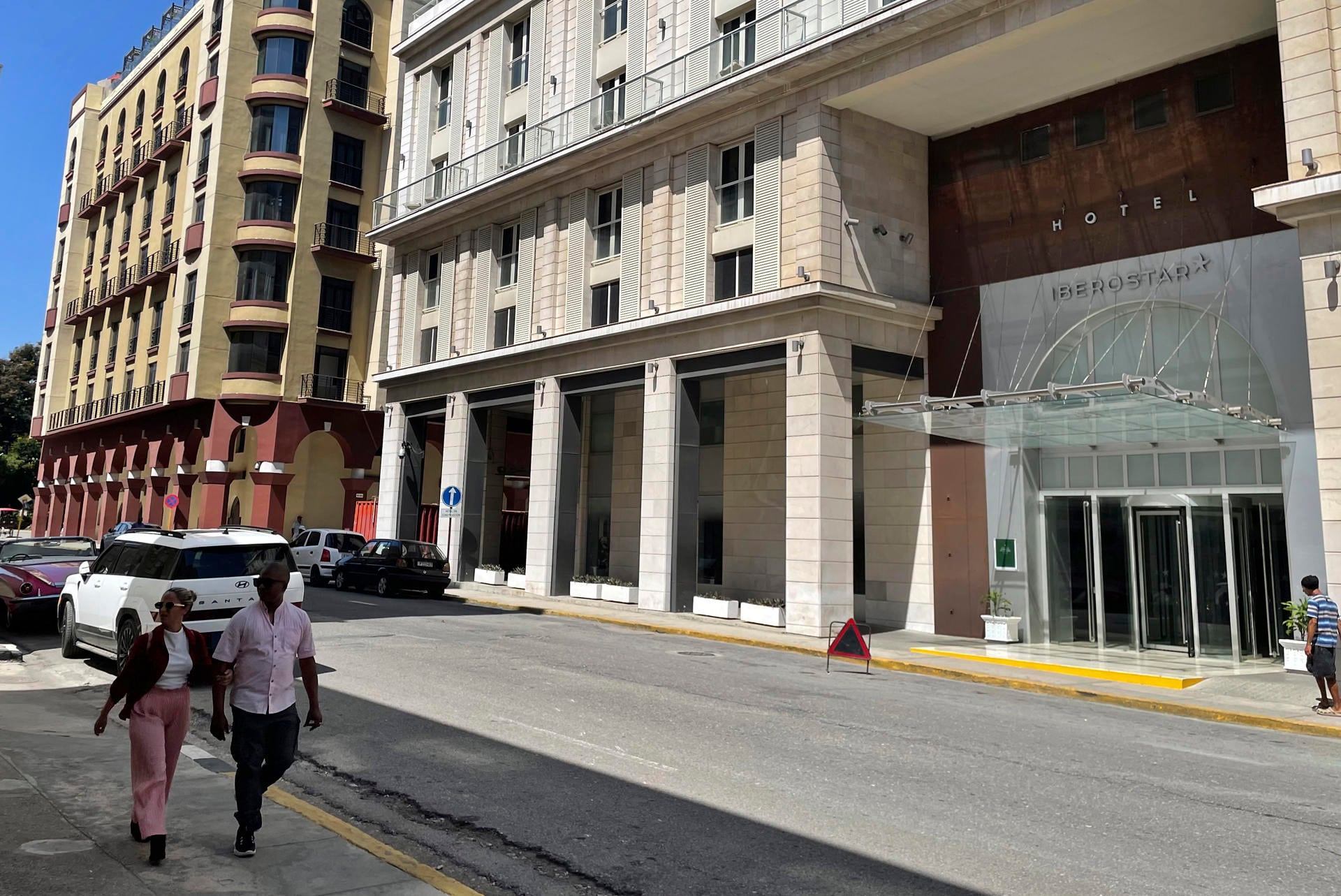 Personas caminan frente a un hotel de la cadena hotelera española Iberostar este miércoles, en La Habana (Cuba) (EFE/ Ernesto Mastrascusa)