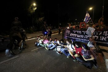 Manifestantes sentados en la calle, mientras exigen la destitución del primer ministro israelí Benjamín Netanyahu, en Jerusalén, el 1 de abril de 2024. REUTERS/Ronen Zvulun