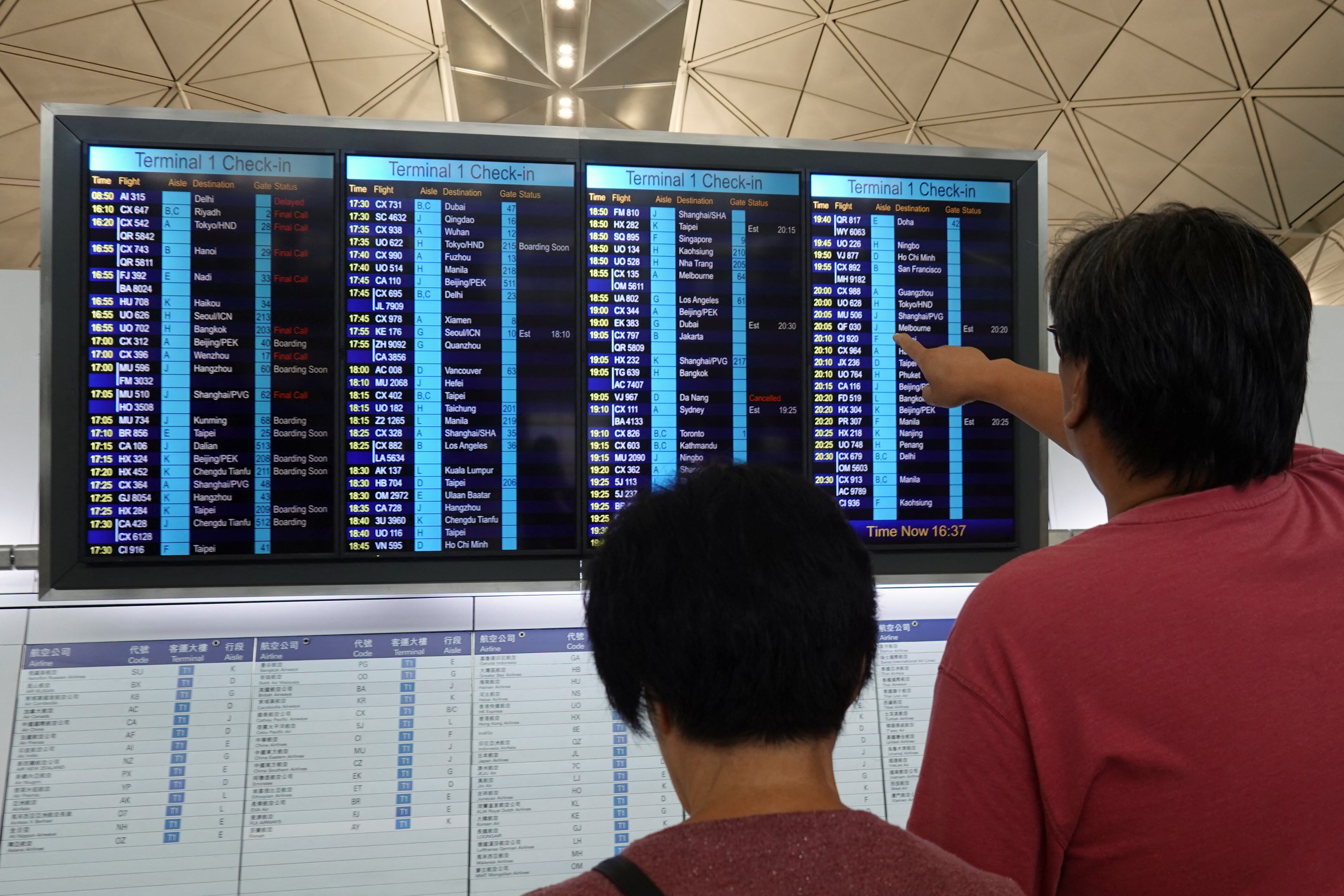 Los pasajeros revisan las pantallas de información de vuelo en el Aeropuerto Internacional de Hong Kong después de que el vuelo AI315, un avión Boeing 787-8 Dreamliner de Air India con destino a Nueva Delhi, regresara a su origen en Hong Kong, tras despegar debido a un presunto problema técnico, en Hong Kong, China, el 16 de junio de 2025. REUTERS/Joyce Zhou