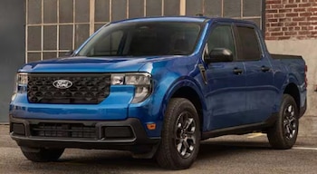 Camioneta Ford Maverick azul estacionada en un ángulo frontal. Presenta faros, parrilla con logo Ford, capó, parabrisas, espejos laterales y ruedas