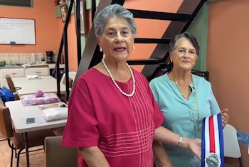 Las hermanas María del Rosario y María Elena Camacho, originarias de Santo Domingo de Heredia, acumulan más de dos décadas de tradición en el bordado de símbolos patrios. (Cortesía: entretenimiento Repretel)