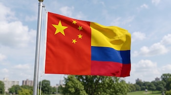 Bandera dividida en dos secciones, con el diseño de China a la izquierda y el de Colombia a la derecha, sujeta a un mástil metálico al aire libre.