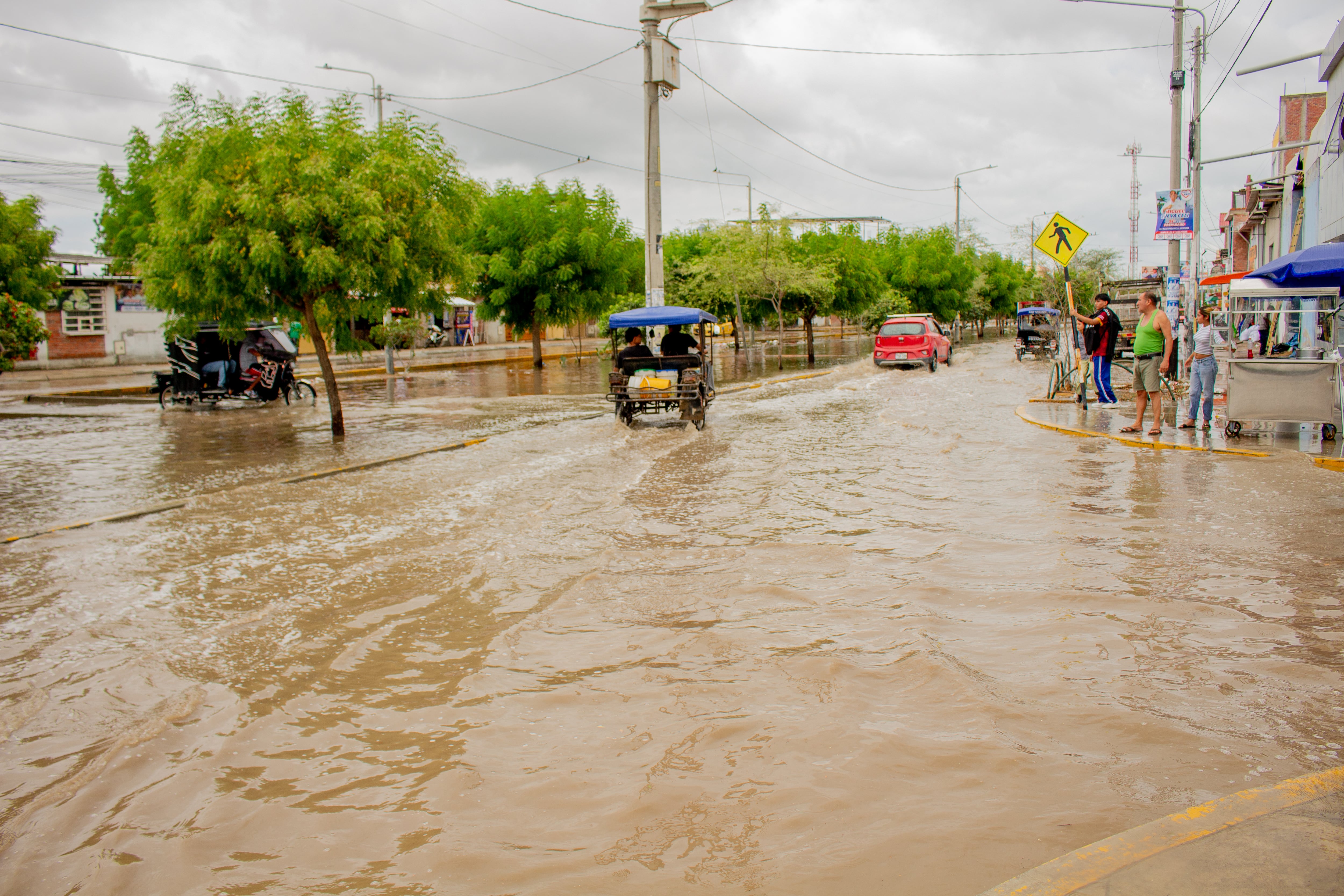 Vehículos y peatones transitan por una calle anegada en Piura tras las intensas precipitaciones asociadas al Fenómeno El Niño. (UNICEF)