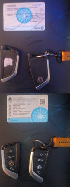 Una cédula de identificación vehicular de la DNRPA y dos llaves de automóvil BMW reposan junto a una correa naranja sobre una superficie oscura.