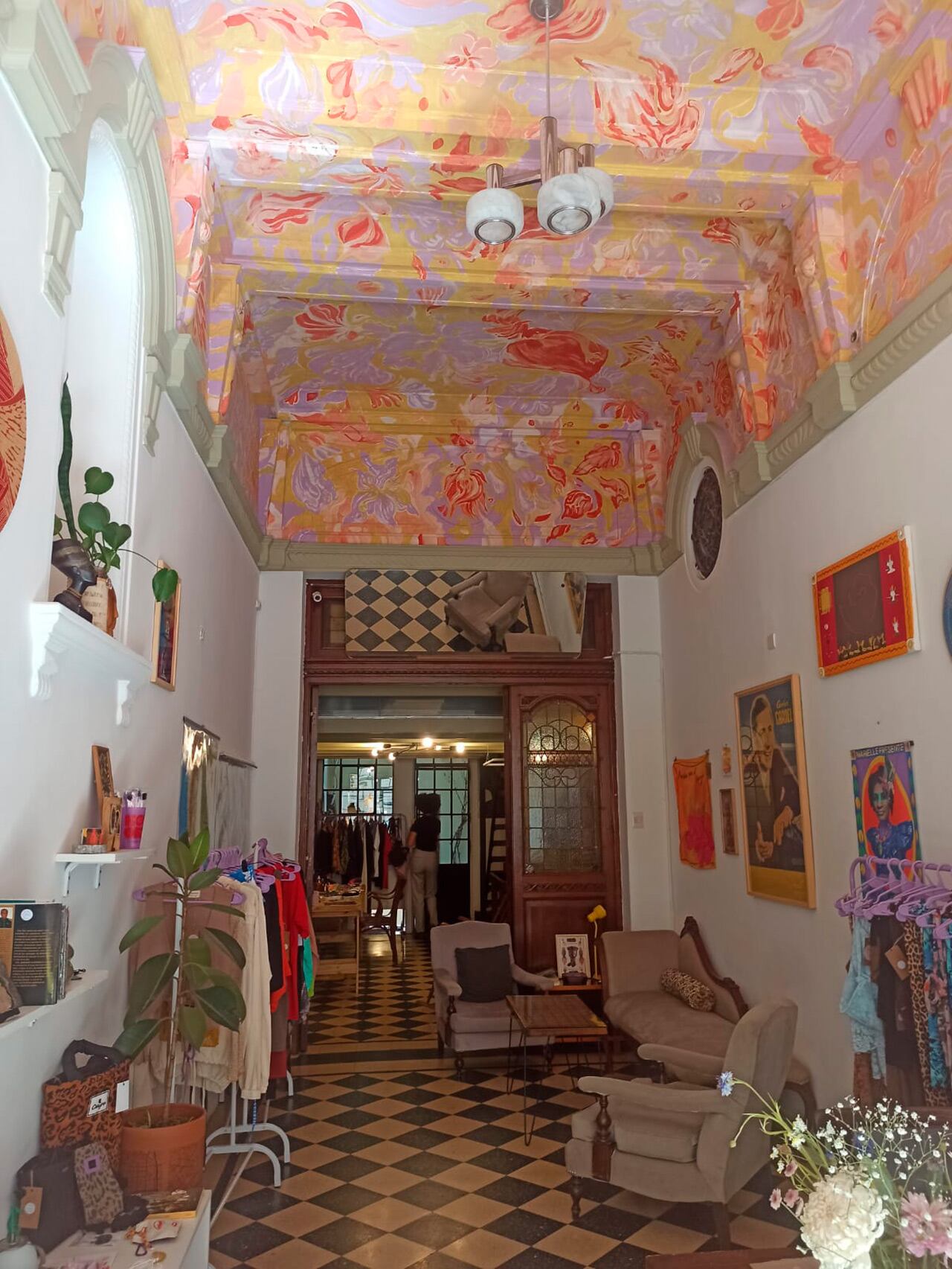 Mariana alquiló el local en plena pandemia, convencida de que en algún momento abriría sus puertas. Una norma la obligaba a tener un lugar físico para ser una agencia de turismo y no se resistió a este sitio con baldosas de damero y aberturas de madera y hierro repujado. El techo, pintado a mano por un amigo, es una obra de arte inspirada en las flores de la primavera porteña