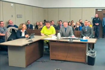 En esta imagen tomada de un video de la Corte de Distrito del Condado El Paso, Anderson Lee Aldrich, de 22 años, en el centro, permanece sentado durante una audiencia en Colorado Springs, Colorado, el martes 6 de diciembre de 2022. (Corte de Distrito del Condado El Paso vía AP)