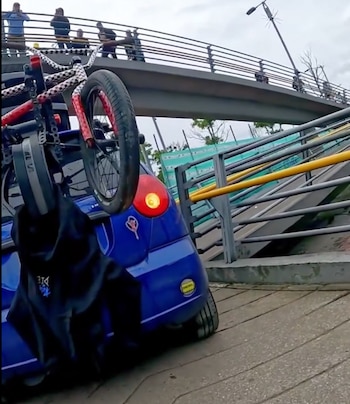 Un Spark azul intentó cruzar un puente peatonal en la carrera 68 con calle 26 de Bogotá y puso en riesgo a peatones y ciclistas - crédito Carlos Fernando Galán/X