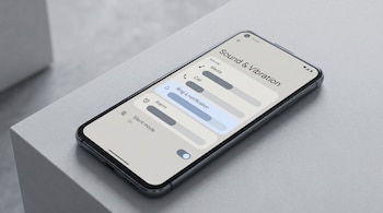Primer plano de un smartphone Android negro sobre una superficie gris, mostrando el menú de ajustes de sonido con barras deslizantes para volumen y el modo silencioso activado.