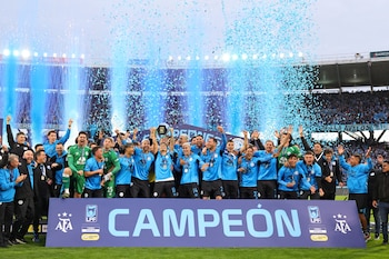 Jugadores del Belgrano sostienen el trofeo y celebran el triunfo ante River Plate en la final del torneo argentino (AP Foto/Nicolas Aguilera)