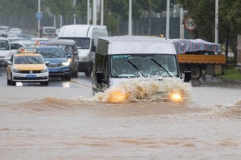 Vehículos avanzan en las vías inundadas en Wuhan (Reuters)