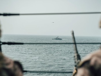 Foto de archivo. Infantes de Marina estadounidenses observan una lancha rápida de ataque iraní desde el buque USS John P. Murtha durante un recorrido por el estrecho de Ormuz, en el golfo de Omán.