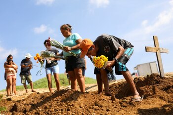 Relatives bury a woman who