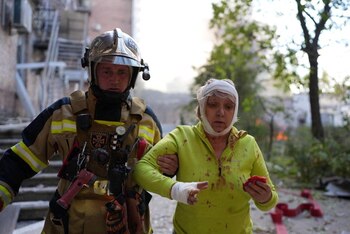 Una mujer herida atendida por los rescatistas tras el bombardeo (REUTERS)
