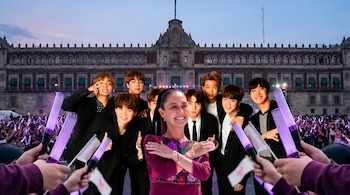 Claudia Sheinbaum sonriente con blusa floral posa con los siete miembros de BTS, de traje, frente al Palacio Nacional y fans con light sticks morados.