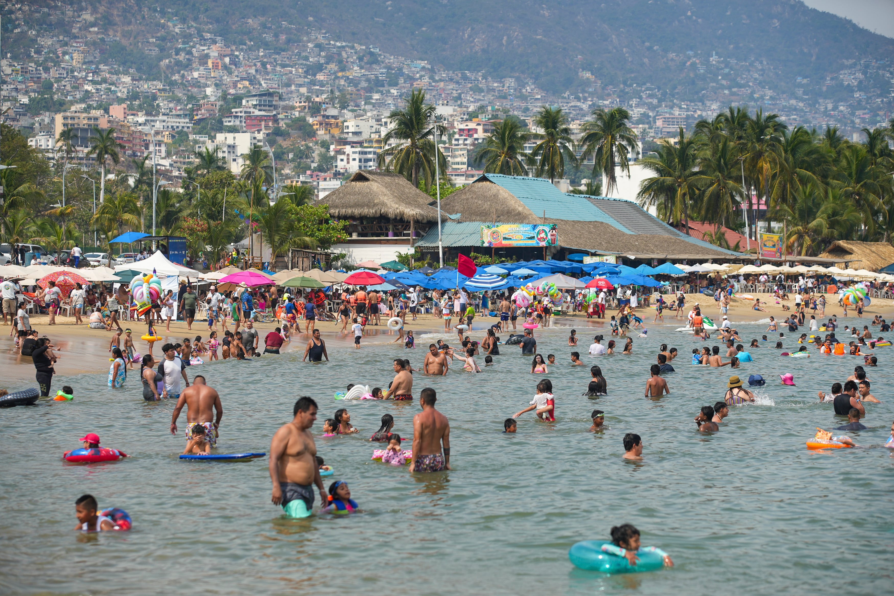 MEX070. ACAPULCO (MÉXICO), 17/04/2025.- Personas disfrutan de una playa en Semana Santa este jueves, en Acapulco (México). EFE/ David Guzmán