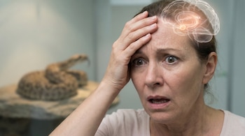 Mujer asustada con sudor visible en la frente y ojos abiertos, mostrando una representación translúcida de la amígdala cerebral. Una serpiente borrosa aparece al fondo.